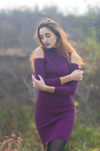 Ragazza in abito lilla sulla natura in autunno Ritratto di una bella ragazza in autunno nella foresta