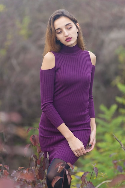 Ragazza in abito lilla sulla natura in autunno, Ritratto di una bella ragazza in autunno nella foresta