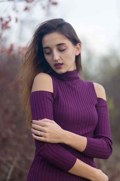 Ragazza in abito lilla sulla natura in autunno Ritratto di una bella ragazza in autunno nella foresta