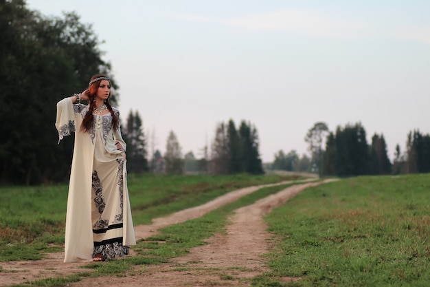 Ragazza in abito lungo strada country