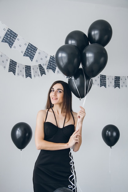 Ragazza in abito nero con palloncini neri