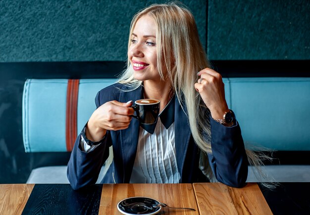 ragazza in abito rigoroso in un bar a bere il caffè