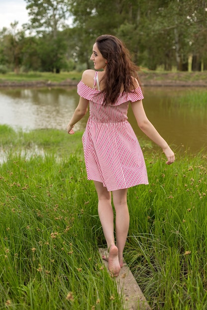 Ragazza in abito rosso sulla natura in estate Ritratto di una bella ragazza in estate nella foresta