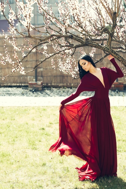 Ragazza in abito rosso vicino al fiore