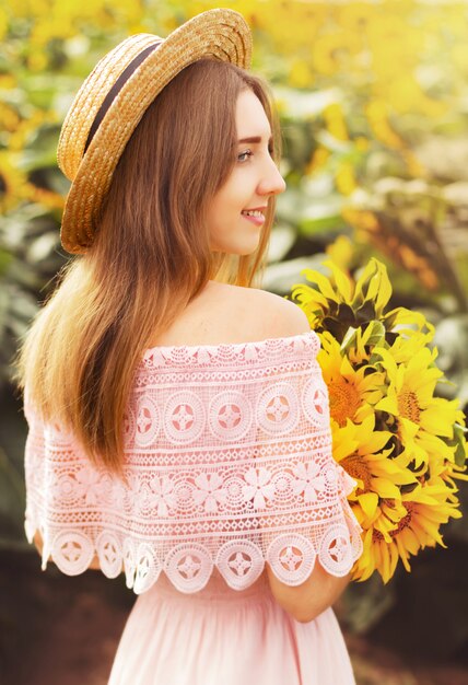 Ragazza in abito tra i girasoli, la ragazza si trova in un campo di girasoli