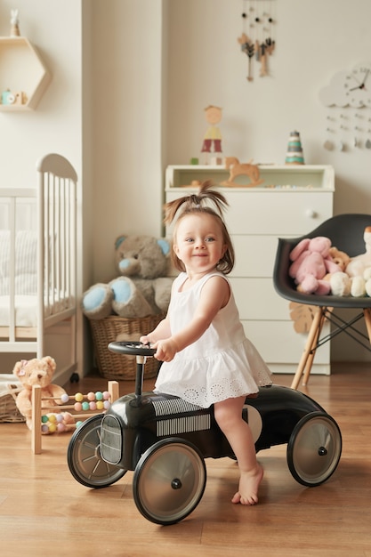 ragazza in auto retrò nella stanza dei bambini