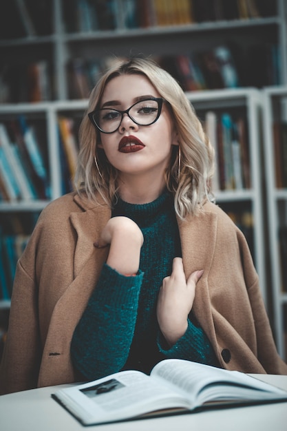 Ragazza in biblioteca a leggere un libro