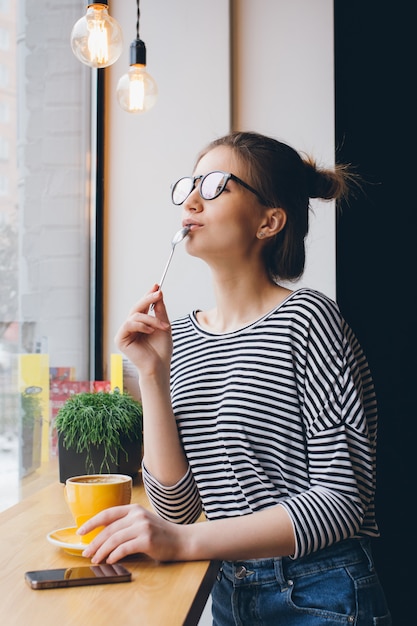 Ragazza in bicchieri a bere il caffè