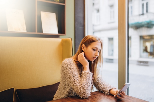 Ragazza in caffè in chat da smartphone