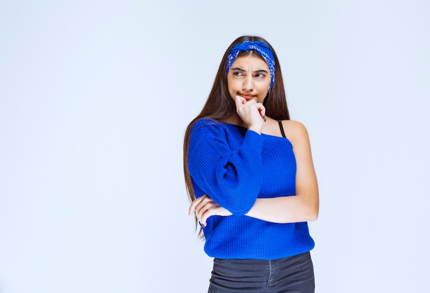 Ragazza in camicia blu pensando e analizzando.