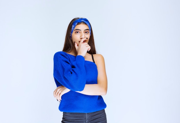 Ragazza in camicia blu pensando e analizzando.