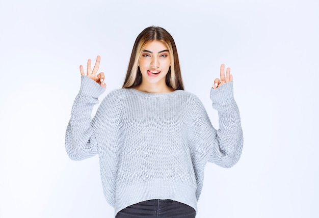 Ragazza in camicia grigia che si sente tranquilla e felice.