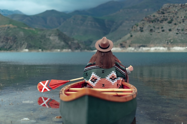 ragazza in canoa su un lago in montagna in una giornata nuvolosa atmosfera lunatica sul lago bylym