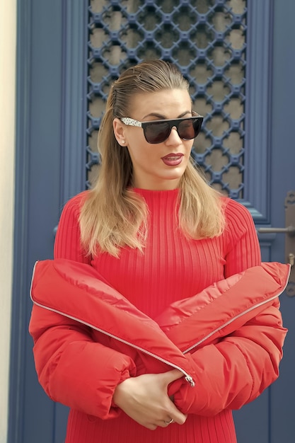 Ragazza in cappotto maglione rosso sulla porta blu a parigi