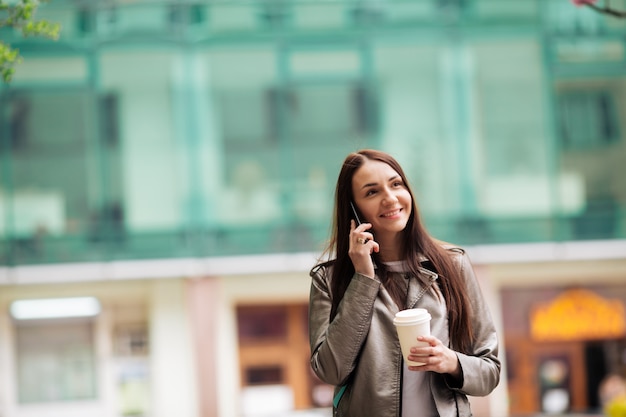 Ragazza in chat al telefono, su sfondo business center