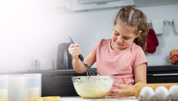 ragazza in cucina che prepara la pasta per i biscotti