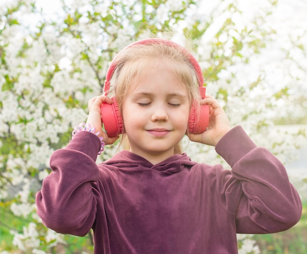 Ragazza in cuffia con gli occhi chiusi ascoltando musica o meditazione all'aperto