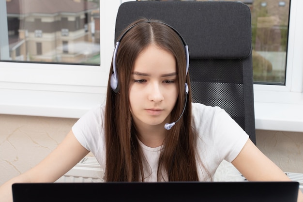 Ragazza in cuffia con microfono da un call center a casa