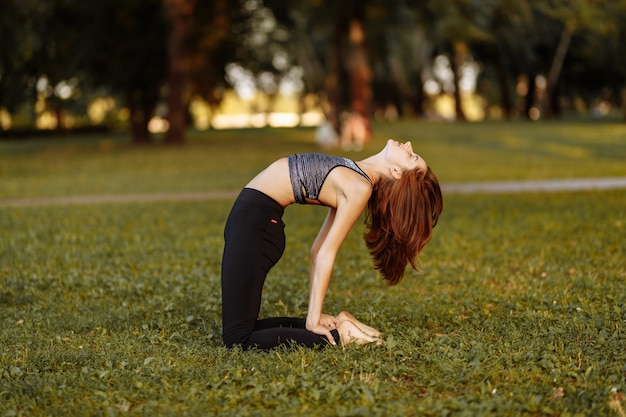 Ragazza in fase di riscaldamento e meditazione nel parco