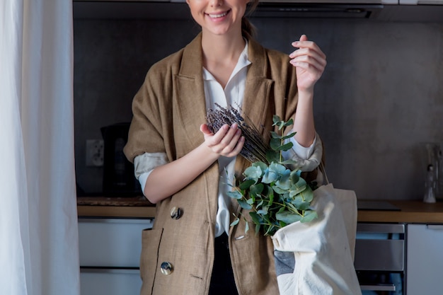 ragazza in giacca con tote bag e piante in una cucina