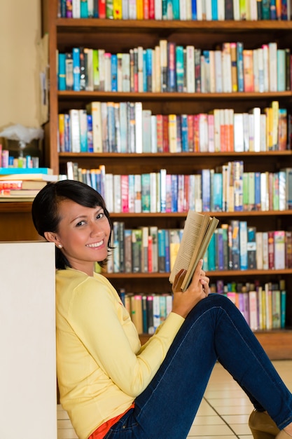 Ragazza in libro di lettura delle biblioteche