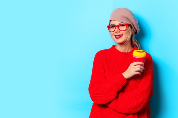 Ragazza in maglione rosso con la tazza di caffè