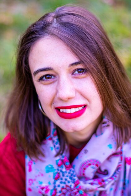 Ragazza in maglione rosso in natura. Ragazza in rosso in natura. Ragazza con le labbra rosse. Foto d'autunno