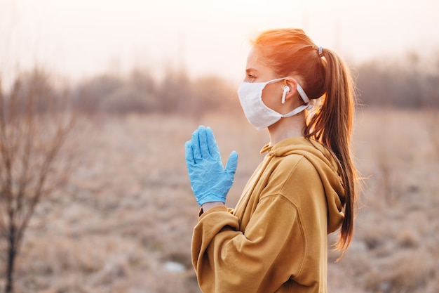 Ragazza in maschera e guanti blu durante la quarantena