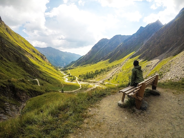 Ragazza in montagna seduto sulla panchina