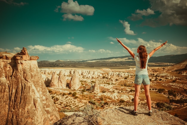 Ragazza in piedi sullo sfondo delle formazioni rocciose della cappadocia nell'Anatolia centrale turchia