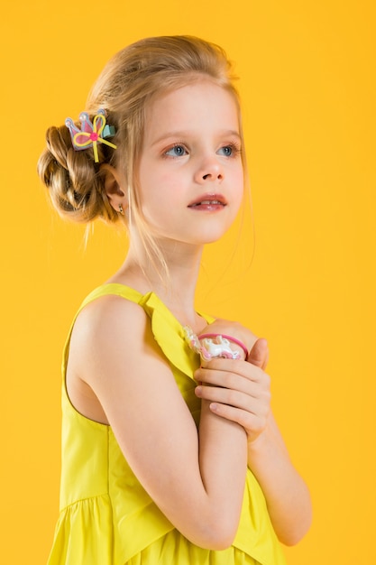 Ragazza in posa su sfondo giallo.