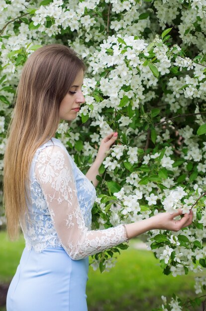 Ragazza in posa su uno sfondo di alberi in fiore