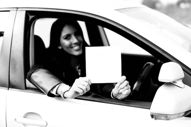 Ragazza in possesso di un poster in bianco bianco in auto