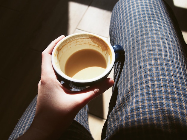 Ragazza in possesso di una tazza di caffè