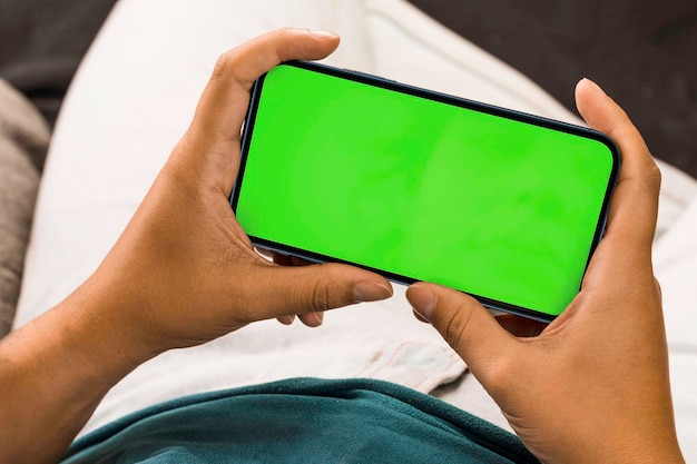Ragazza in possesso di uno smartphone con Chroma Key a schermo verde