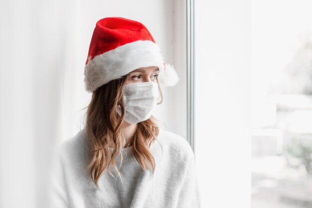 ragazza in santa cappello che indossa maschera medica