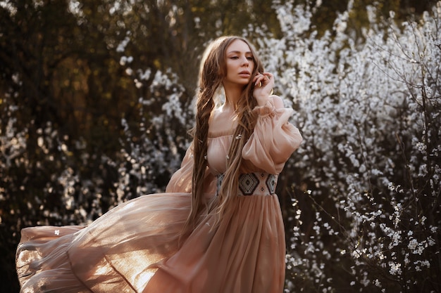 ragazza in un abito lungo. ritratto di primavera in giardino. bellissimo vestito etnico