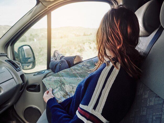 Ragazza in un'automobile che tiene una mappa