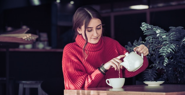 Ragazza in un bar a bere il tè