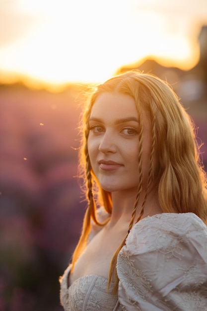 Ragazza in un campo di lavanda Donna in un campo di fiori di lavanda al tramonto in un abito bianco Francia Provenza