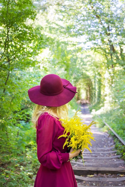 Ragazza in un cappello con un mazzo di fiori gialli