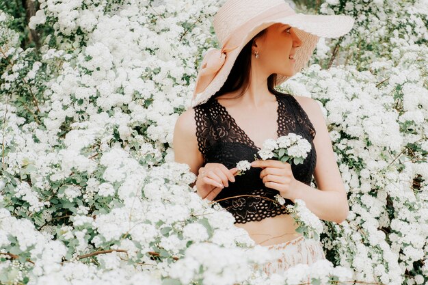 Ragazza in un cappello in un giardino fiorito