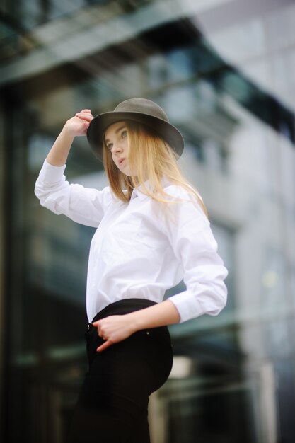 Ragazza in un cappello su uno sfondo di vetro