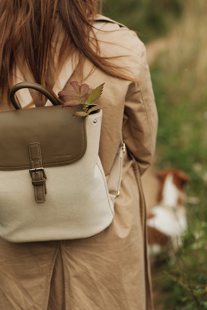 Ragazza in un cappotto beige con una moda di close-up zaino