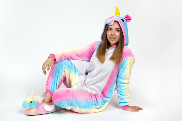 Ragazza in un costume da unicorno viola in studio su sfondo bianco.