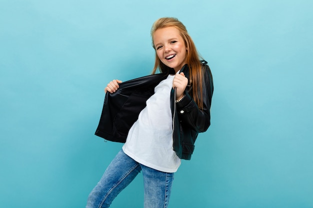 ragazza in un look casual con una giacca di pelle e jeans slacciata la giacca su azzurro