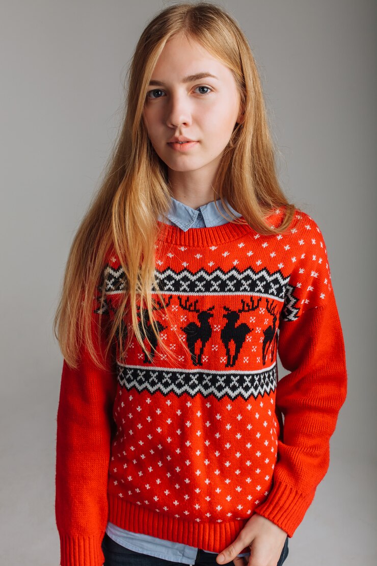 Ragazza in un maglione di Natale o Capodanno in studio con una tazza di caffè aromatizzato. Posto isolato per l'umore di Natale del testo.