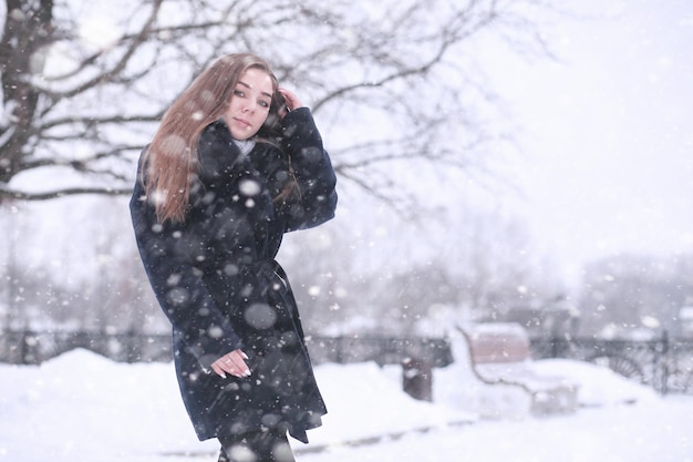 Ragazza in un parco invernale nel pomeriggio in caso di nevicate