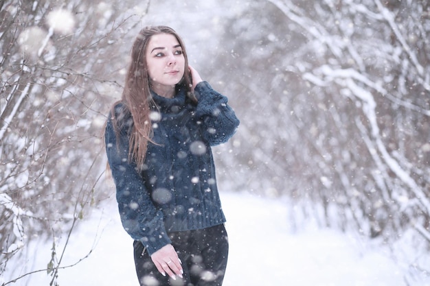 Ragazza in un parco invernale nel pomeriggio in caso di nevicate