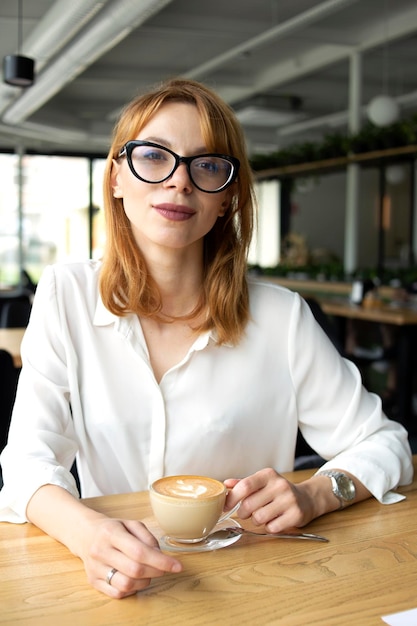 Ragazza in un vestito con una tazza di caffè